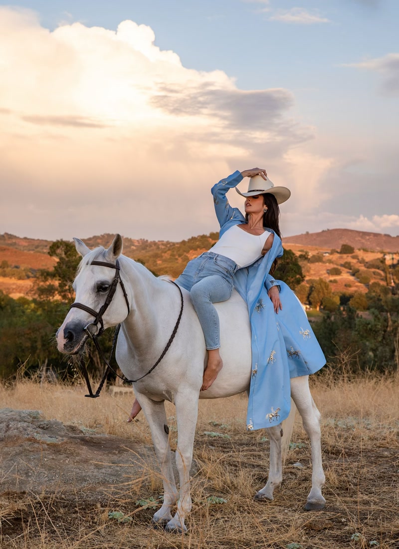 Editorial western glam on a white horse at golden hour